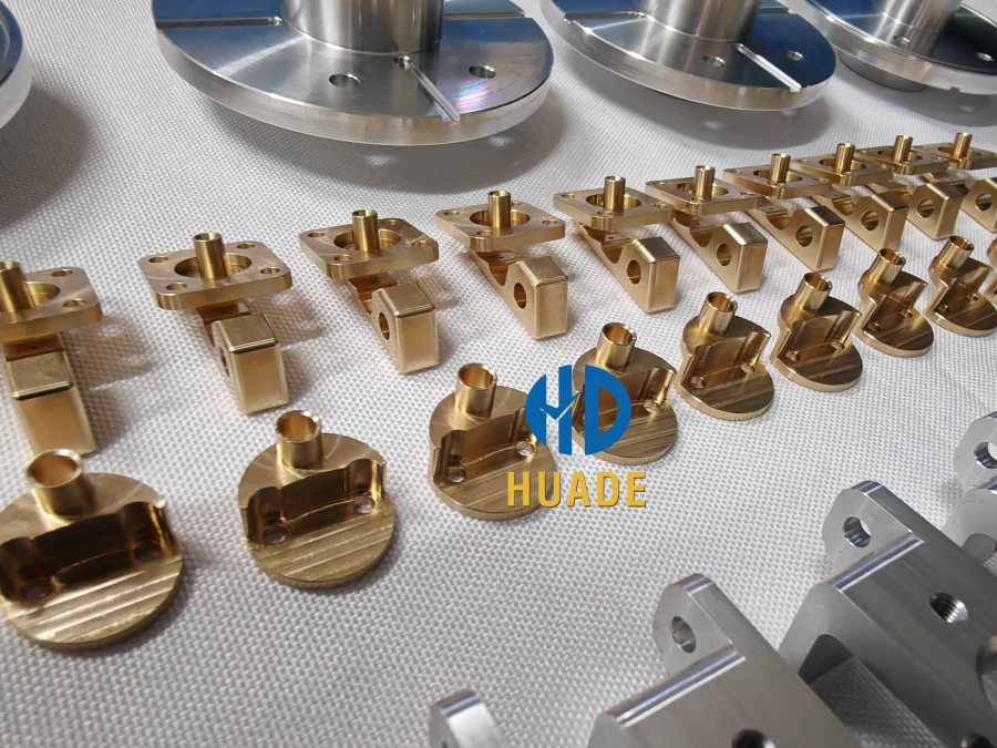 Small-batch CNC machined aluminum and brass parts neatly arranged on a white background, showing finished components for different applications.