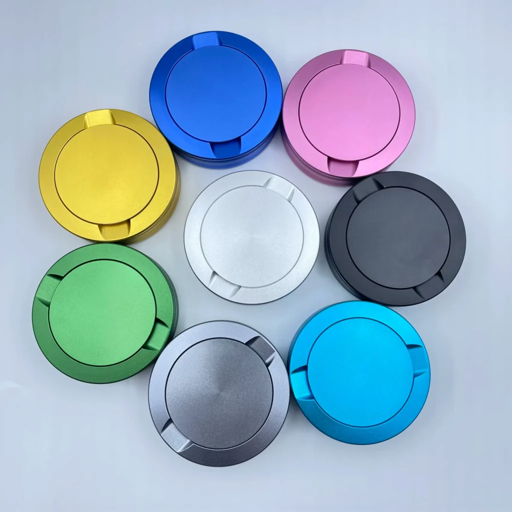 A variety of colorful anodized aluminum snus cans including black, blue, silver, and gold.
